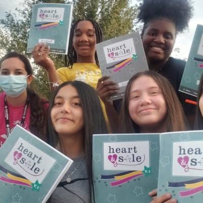 Heart & Sole girls holding up their journals